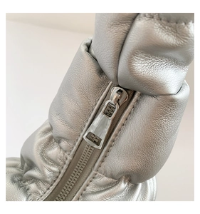Macro detail of silver pleated faux leather fabric and metallic zipper closure