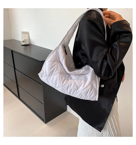 Detalle del bolso hobo acolchado blanco con costuras de diamante y cremallera negra