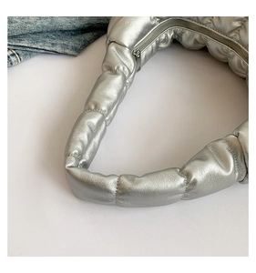 Detail view of silver quilted cloud bag with metallic texture and durable metal zipper