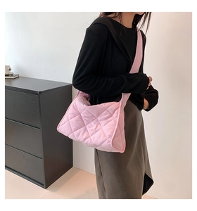 Détail de la texture d'un sac à bandoulière en nylon rose avec motif matelassé