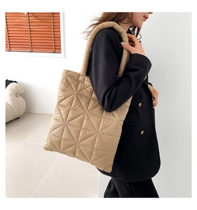 Khaki quilted puffer tote bag with diamond stitching shown on model shoulder