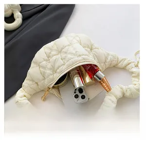 Top view of cream cloud bag showing internal capacity with phone and cosmetics
