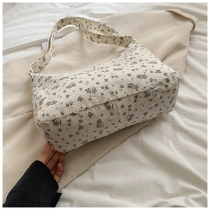 Gros plan d'un sac cabas floral crème en tissu seersucker texturé avec bandoulière large