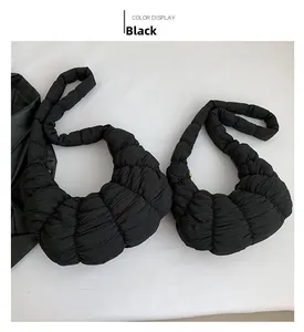 Detail view of black pleated dumpling bag showing rich quilted texture and puffy nylon material