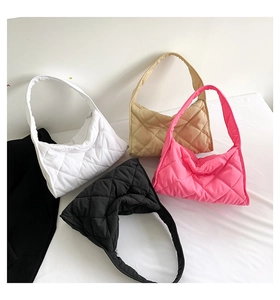 Bolsos hobo acolchados en colores blanco, beige, rosa y negro sobre superficie blanca