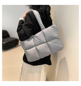 Detailansicht der großen gesteppten Puffer-Tasche in Hellblau an einem weiblichen Model