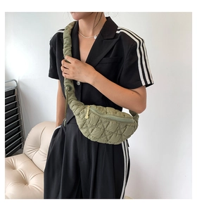 Close-up of quilted military green chest bag with ruched strap and gold zipper