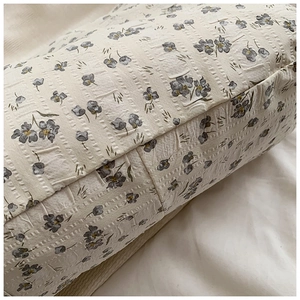 Gros plan sur la texture florale beige avec motifs bleus et finition en seersucker
