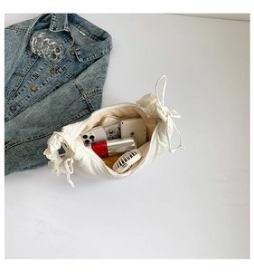 Interior view of white ruched shoulder bag showing space for phone and cosmetics