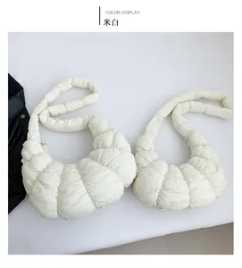 Detail of off-white dumpling bag showing unique bubble textured fabric and minimalist design