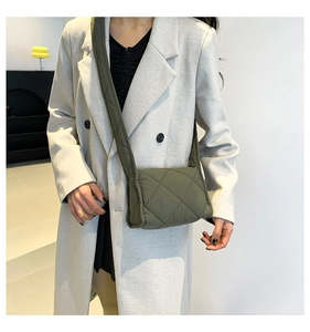 Detailopname van de olijfgroene gewatteerde crossbodytas met ruitvormige stiksels