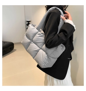 Makroaufnahme der grauen gesteppten Puffer-Tasche mit feiner Textur und sanftem Glanz