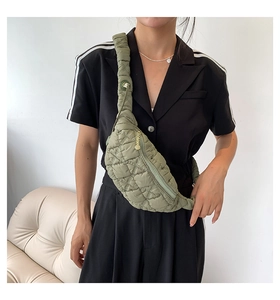 Close-up of military green quilted puffer bag detail with premium metallic zipper texture