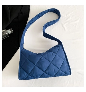 Gros plan détaillé du sac bandoulière matelassé bleu avec texture losange douce