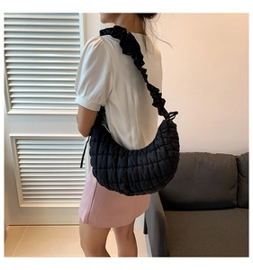 Detail view showing black quilted hobo bag texture and scrunchie-style shoulder strap