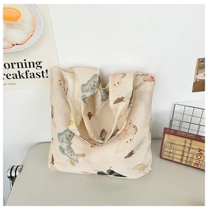 Detailed macro view of the canvas fabric texture and butterfly print on a tote bag