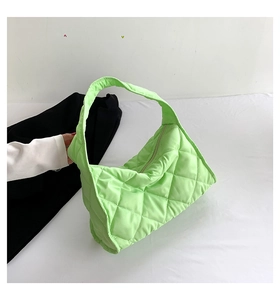 Detalle de bolso tote acolchado verde claro con patrón de diamantes y cremallera