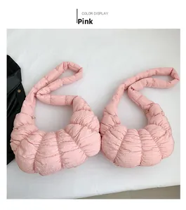 Detailed view of two pink pleated dumpling bags with quilted texture and wide straps