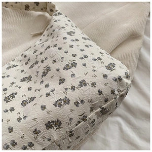 Gros plan sur la texture jacquard à fleurs et les coutures de ce sac fourre-tout