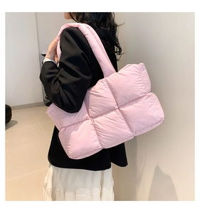 Detailansicht eines Modells mit einer großen rosa gesteppten Puffer-Schultertasche