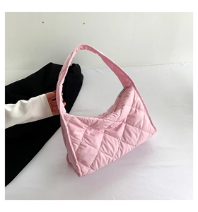 Primer plano de bolso tote rosa acolchado con diseño de rombos y cierre de cremallera