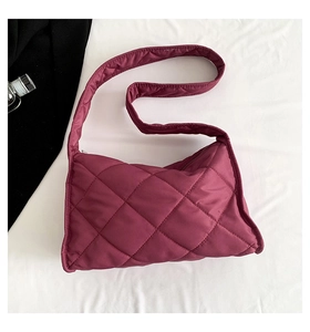 Gros plan sur le sac en nylon bordeaux matelassé avec un motif de losanges doux