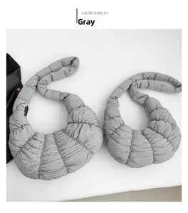Detail view of two grey quilted puffer bags with pleated texture and soft padding