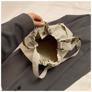 Close-up of cream nylon tote bag interior with magnetic snap and drawstring detail