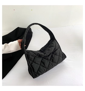 Detalle de un bolso tote acolchado negro con costuras clásicas en forma de diamante