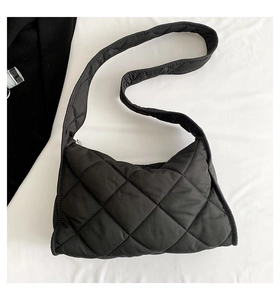 Gros plan détaillé sur la texture matelassée en losanges du sac à bandoulière noir
