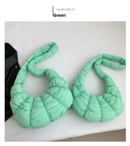 Detail view of the light green quilted dumpling bag showing pleated nylon fabric texture