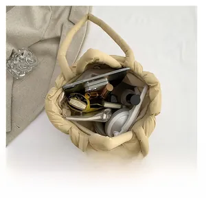 Macro shot of spacious beige quilted tote bag interior holding iPad and accessories