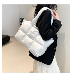 Detailansicht der leichten weißen gesteppten Puffer-Tasche an einer Modeschulter