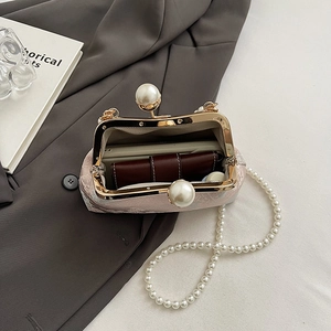 Detailed view of pink floral silk clutch with pearl strap and vintage golden clasp