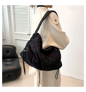 Detailaufnahme der schwarzen gesteppten Nylon-Tragetasche mit Rautenmuster und Kordelzug