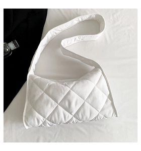 Détail d'un sac à bandoulière matelassé blanc avec motif de losanges minimaliste