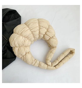 Detail view of cream pleated croissant bag with gold zipper and stylish wide shoulder strap