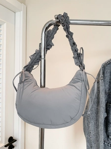 Grey crescent quilted puffer underarm bag with pleated strap and drawstring details