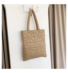 Close-up of khaki quilted down tote bag showing geometric triangle stitching texture