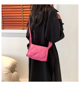 Achteraanzicht van een model met de gewatteerde roze crossbodytas met ruitjespatroon