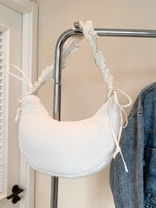 White puffy crescent underarm bag with pleated strap and side tie detail design
