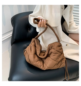 Detail einer braunen gesteppten Nylon-Hobo-Tasche mit Rautenmuster und weicher Textur