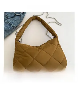 Vue détaillée du sac matelassé marron avec surpiqûres en losanges et fine chaîne en argent