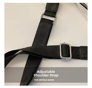 Detail of adjustable black woven shoulder strap with metallic buckle and embossed texture