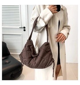 Dunkelbraune gesteppte Puffer-Handtasche kombiniert mit minimalistischem cremefarbenem Mantel