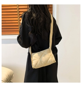 Gedetailleerd achteraanzicht van een beige gewatteerde crossbodytas met ruitpatroon