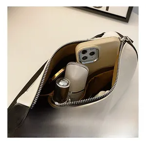 Detail view of the spacious inner compartment with lining for this cylinder crossbody bag