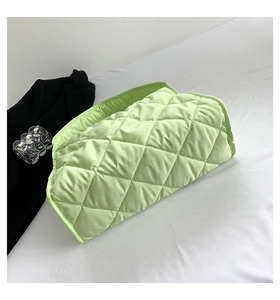 Detalle del bolso tote acolchado verde claro con textura de diamantes y diseño minimalista