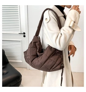 Seitenansicht einer dunkelbraunen Stepptasche mit Kordelzug-Detail an einem Model