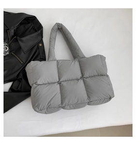 Detailaufnahme der grauen gesteppten Puffer-Tasche mit weich gepolsterten Tragegriffen